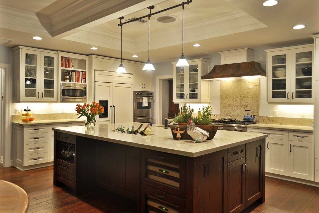 Stylish kitchen with white cabinetry, large island, stainless steel appliances, pendant lighting, and granite countertops, perfect for modern home construction and renovation projects.
